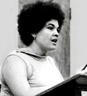 a black and white photo of a woman delivering a speech