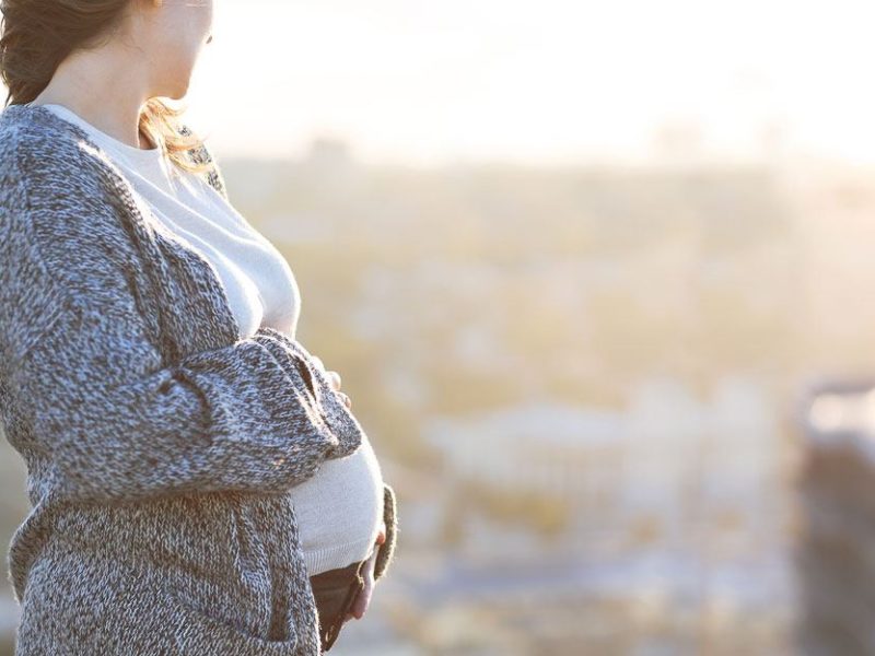 pregnant woman standing against skyline