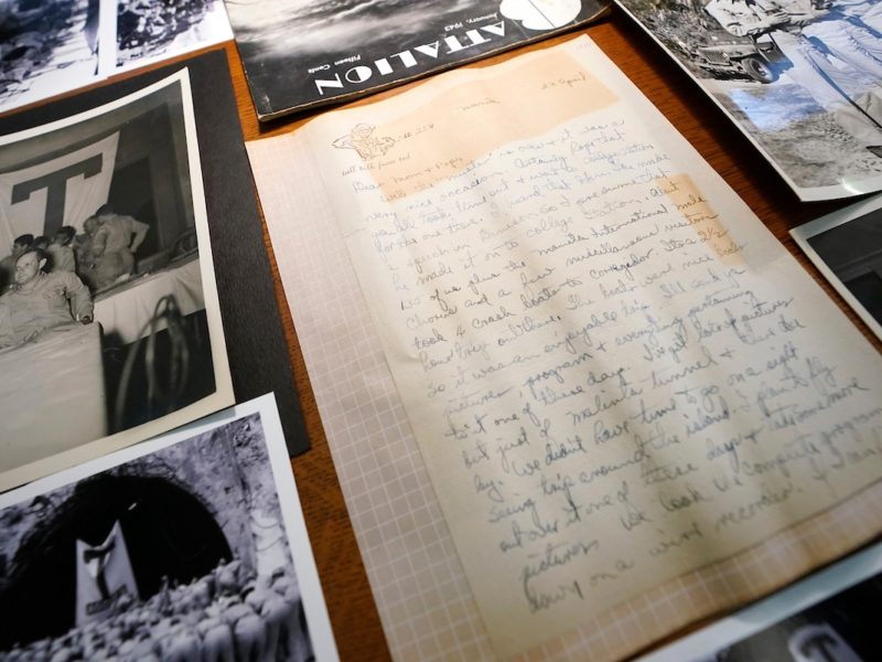 overhead view of a letter and black and white photographs laid out on a table