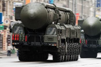 a photo of a Russian military truck carrying a nuclear missile through the streets of Moscow as another follows close behind