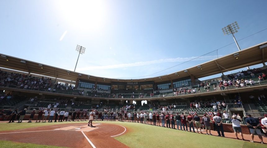 Fans and players standing to salute the nation's military at the March 27 Aggie Baseball game at Olsen Field at Blue Bell Park.