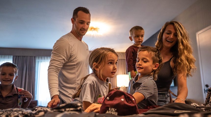The McLean family in their room at the Texas A&M Hotel & Conference center discovering free swag from OHT left in the room by A&M staff members