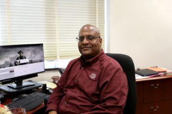 leroy dorsey sitting at a desk with a computer monitor in the background showing a photo of theordore roosevelt