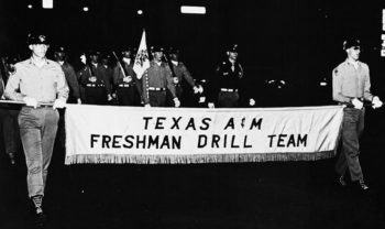 a historic photo of the drill team holding a sign that reads Texas A&M Freshman Drill Team
