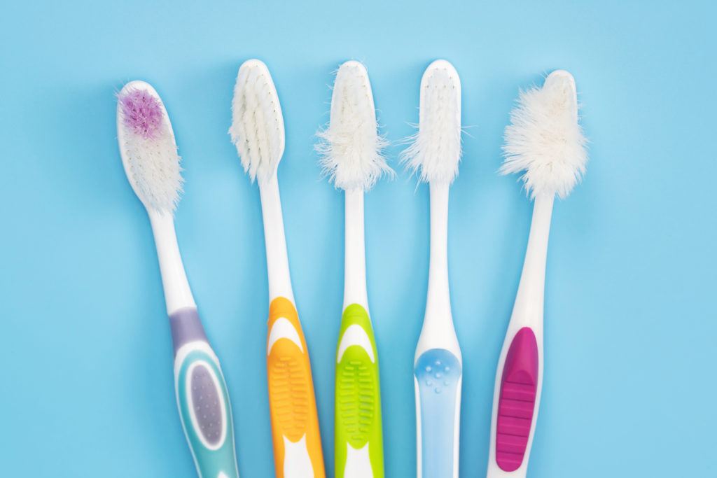High Angle View Of Old Toothbrushes On Blue Background