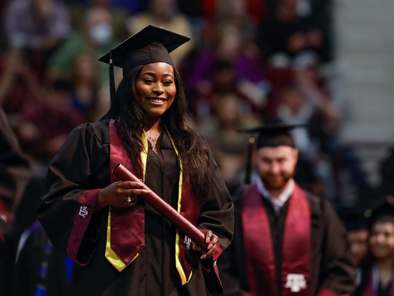 graduates cross the stage at Reed Arena