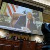 an image of donald trump is projected on a screen behind a row of lawmakers sitting behind a dais during a hearing
