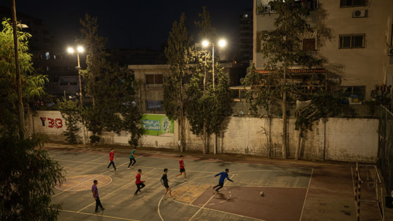 view of young people playing soccer on an outdoor court in Gaza