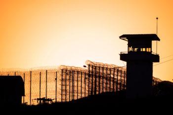 Stock image of the exterior of a prison at sunset