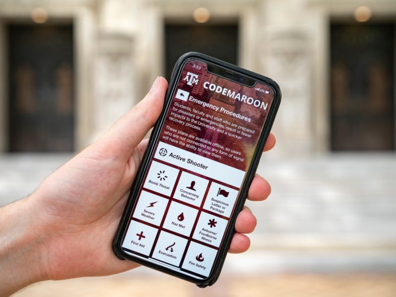 a photo of a hand holding an iphone with the code maroon app open to the emergency procedures screen
