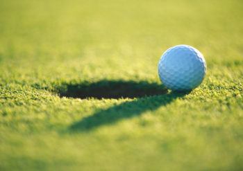 a photo of a golf ball on the edge of the hole
