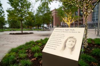 A dedication plaque for Shannon Lia Roberts in Aggie Park, with Kyle Field in the background