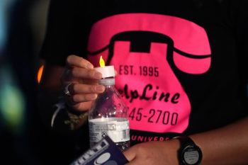 Close-up photo of someone wearing a T-shirt with a graphic of a pink telephone and the HelpLine photo