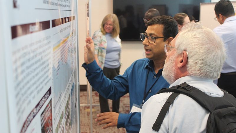 researchers discussing during a poster session
