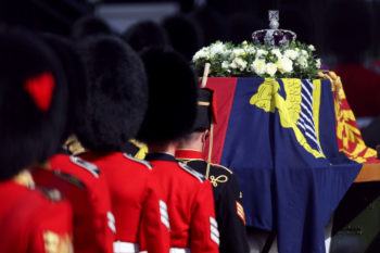 The Imerpial Crown sitting on top of Queen Elizabeth's coffin, which is drapd with flowers and a flag