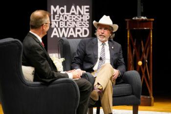 Bieber Aplin on stage wearing a cowboy hat.A banner in the background reads: "McLain Leadership in Business Award"
