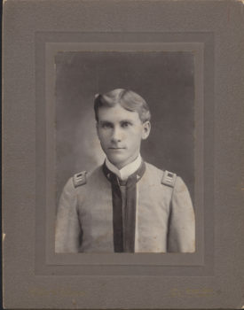 an old black and white portrait of a young straight-faced man in a cadet uniform