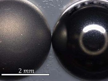 a magnified photo of two spheres, one notably rougher than the other