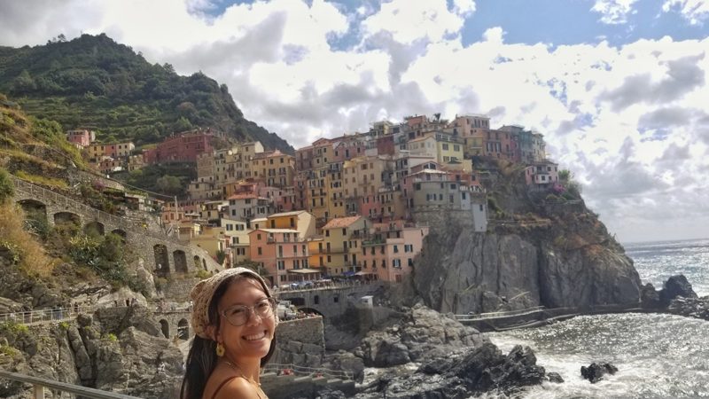 an Aggie standing seaside on a study abroad trip to Italy