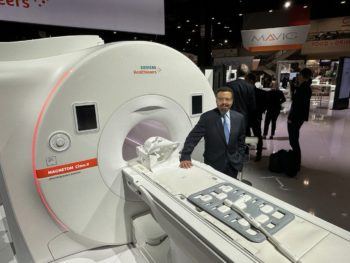 Roderic Pettigrew standing next to the Cima MRI machine