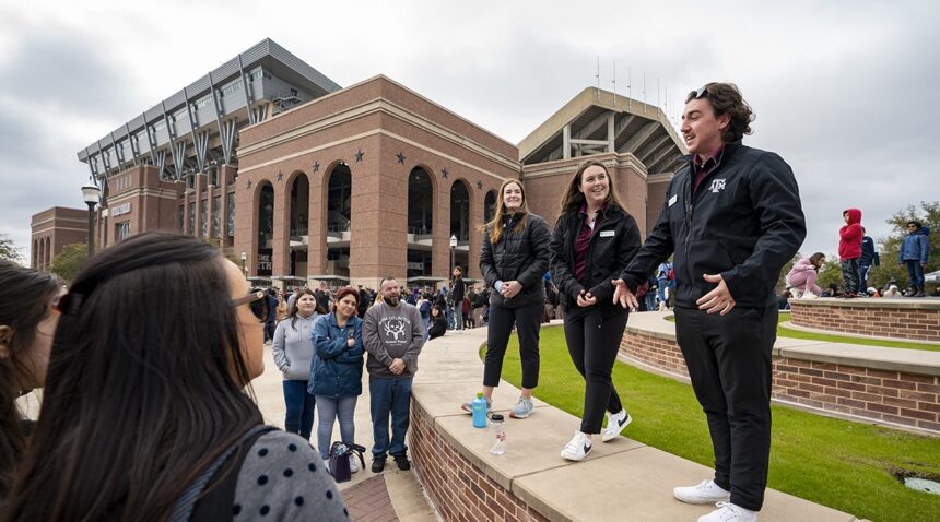 Tour guides speaking to visitors near Kyle Field
