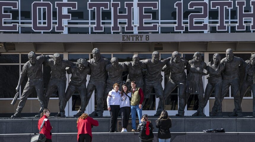 visitors to Aggieland Saturday in front of the war hymn statue