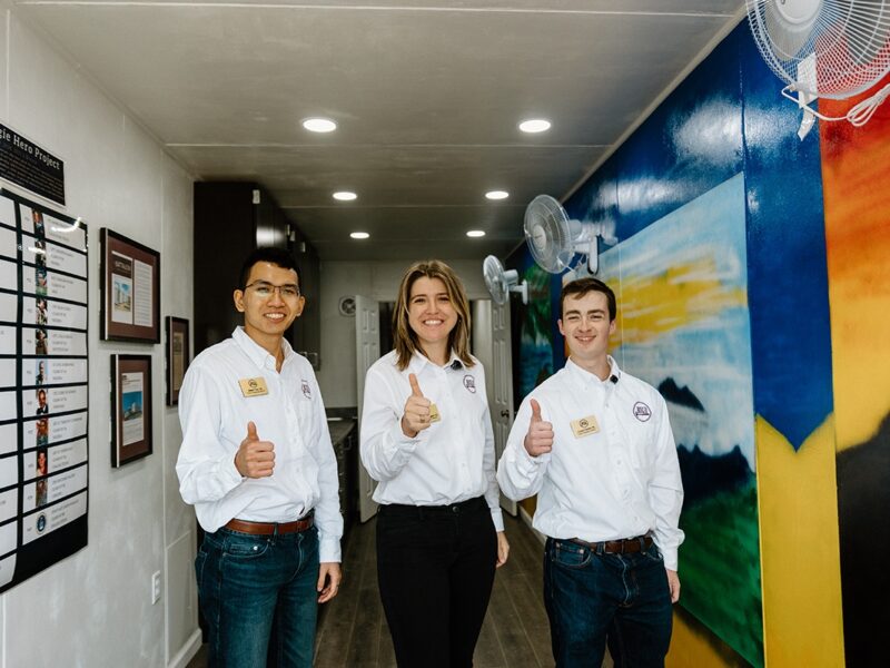 BUILD Chief Operating Officer Chase Parrish '24, Chief Financial Officer Albert Tran '24 and Chief Executive Officer Kate-Riley Rogers stand inside of the Ukraine TAMC