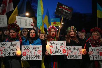 Women with fake blood on their faces hold placards as they take part in a rally outside the Russian Embassy to mark the first anniversary of Russia's invasion of Ukraine, on February 24, 2023 in London, United Kingdom.