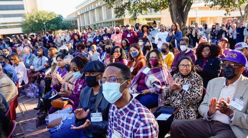 a photo of a bunch of people, many wearing mask, sitting in chairs near the Memorial Student Center