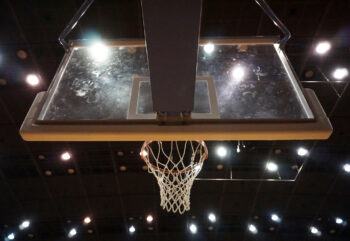 Low angle view of back of basketball hoop in an illuminated stadium