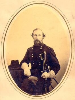 a portrait of a man in a union military uniform with shaggy hair and a full beard