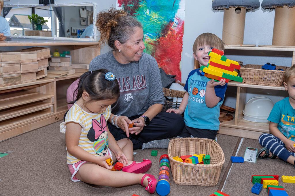 a woman with two children who are playing with toys