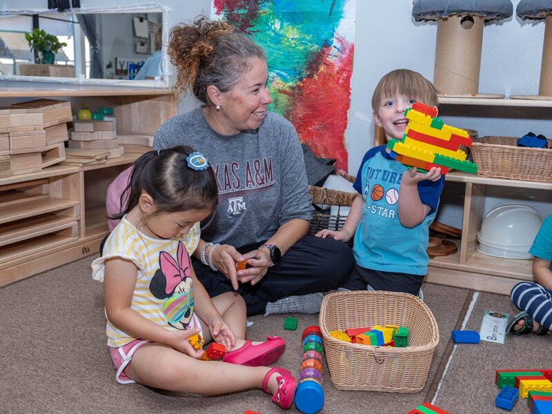 a woman with two children who are playing with toys