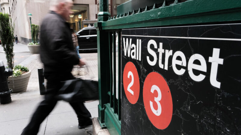 People walk along Wall Street outside of the New York Stock Exchange