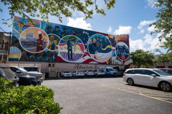 a photo of a colorful mural on the side of a building in Galveston, depicting various scenes related to slavery and emancipation