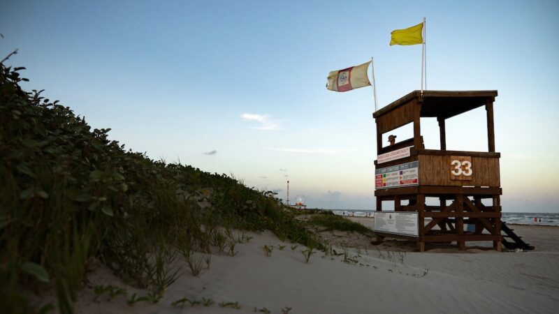 Sand dune with lifeguard tower on the beach at sunset