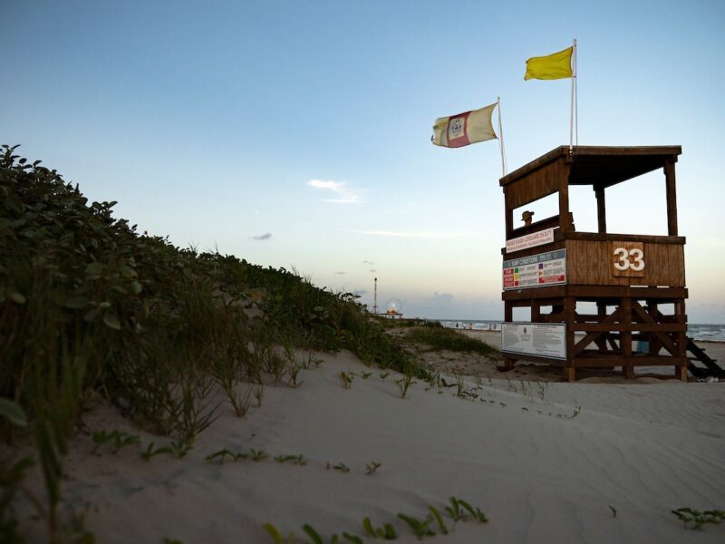 Sand dune with lifeguard tower on the beach at sunset