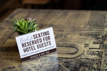 a photo of a table with a plant and a sign saying "reserved for hotel guests"