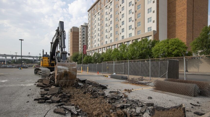 a backhoe tearing up the a parking lot on the future site of Texas A&M-Fort Worth