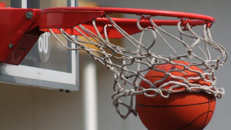 a close-up photo of a basketball swishing through the net of a basketball hoop