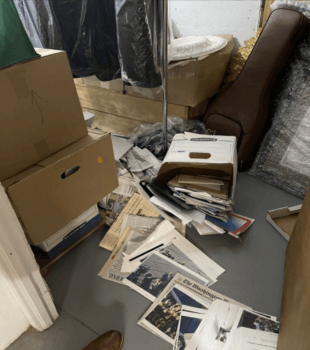 Boxes of documents spill out onto the floor of a storage room