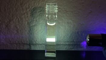 Dissolved organic matter in this cuvette shows fluorescence, which is the process of light being emitted from excited electronic states.