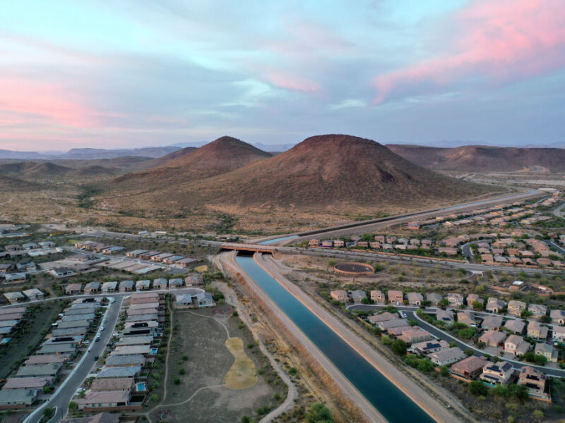 Aerial view of an Arizona suburb with a canal running past homes