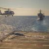 a helicopter landing on an aircraft carrier