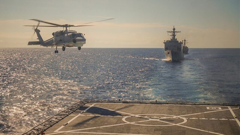 a helicopter landing on an aircraft carrier