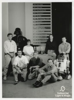 A photo of a group of people posing with Darth Vader and R2-D2.