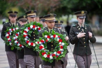 a photo of cadets in midnights uniforms carrying red white and blue wreaths on the Corps of Cadets quad