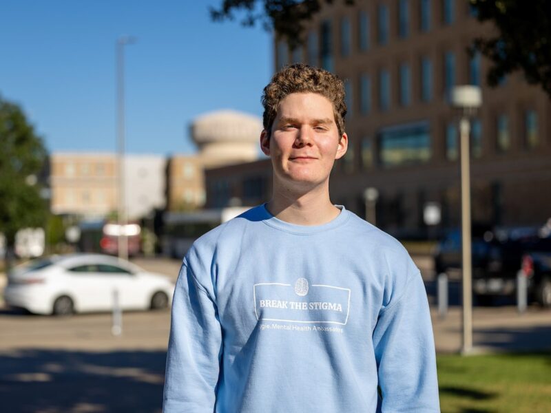 a young man in a blue sweatshirt that reads 