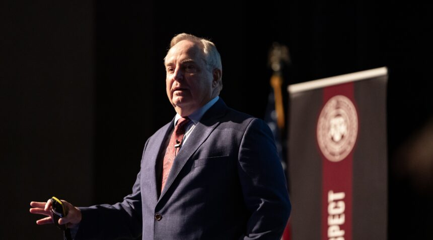 a photo of Mark A. Welsh III delivering the State of the University address on the Rudder Theatre stage.