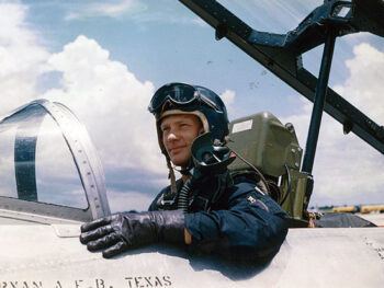 a photo of a young Buzz Aldrin in the cockpit of a plane with BRYAN A.F.B. TEXAS painted on the side